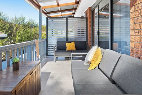 Spacious covered rear patio with outdoor furnishings and bbq