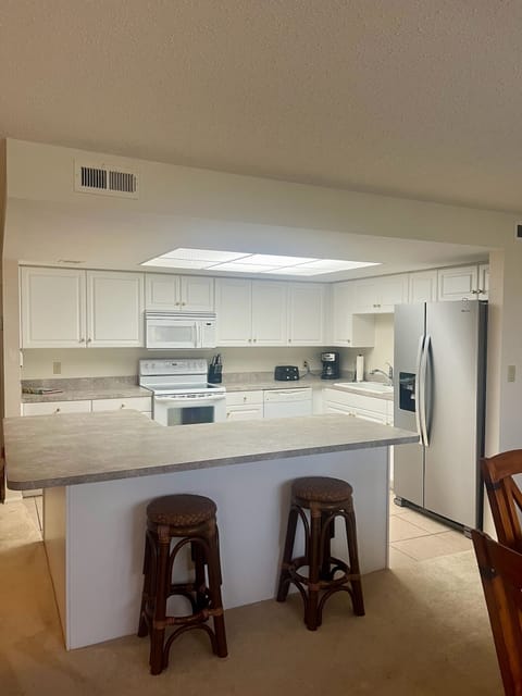 The private kitchen includes an island with two bar stools for extra seating