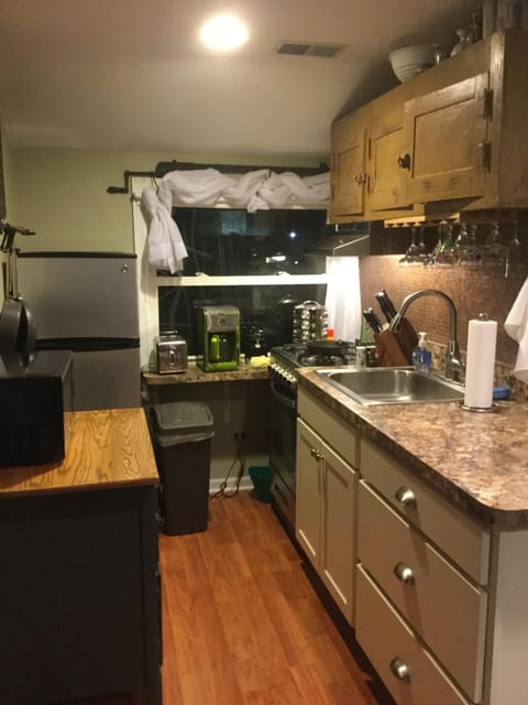Kitchen with gas stove, fridge, microwave, coffee maker, toaster .