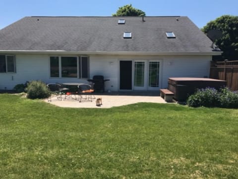 Large patio with hot tub and gas grill.