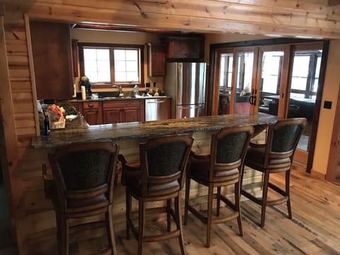 Bar top seating and sliding doors open into screen porch for extended dinning.