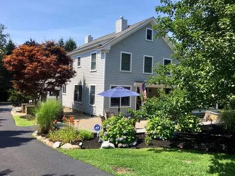 Front of House with large patio and long driveway on the left.