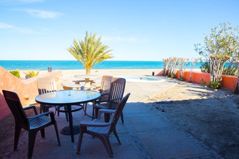 Back deck of the villa with outdoor seating, a pool, and a grill 