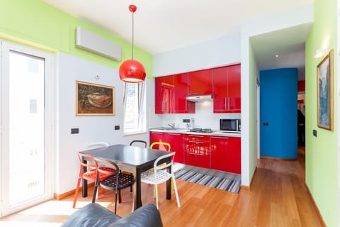 Living room with fully equipped kitchen and dining area.