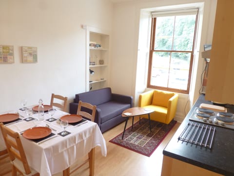 The living room has a kitchen area and a dining table that seats four