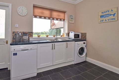 Kitchen with washing machine, microwave and dishwasher