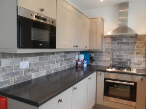 Microwave with cleaning equipment above, electric oven and gas hob