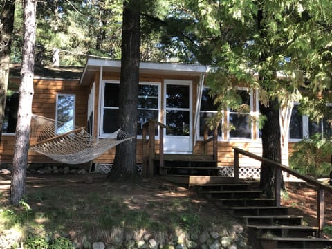 New cedar siding this year (2022), view from the patio up to the cottage porch. 