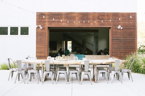 Outdoor dining area connects to house through roll up garage door. 