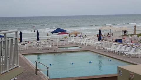 Close up view from apartment balcony of pool deck and ocean. 