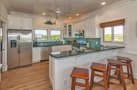 Well appointed kitchen with bar seating opens to the dining area.