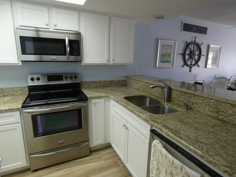 Newly remodeled kitchen with stainless steel appliances, granite, wood cabinets.