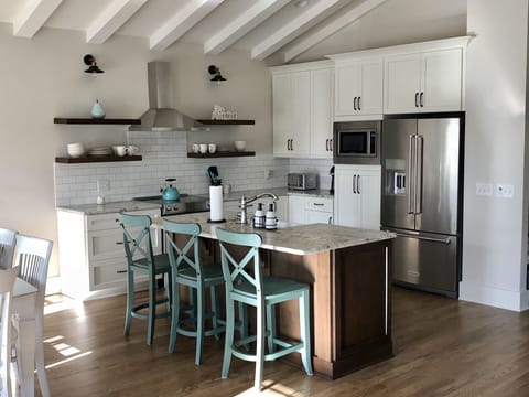 Leathered granite island with seating for 4 (3shown in picture) open shelving