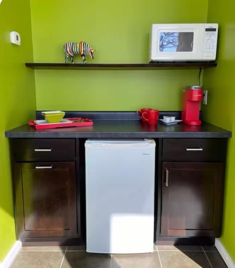 The is a kitchenette with small refrigerator, coffee maker, basic service for 2.