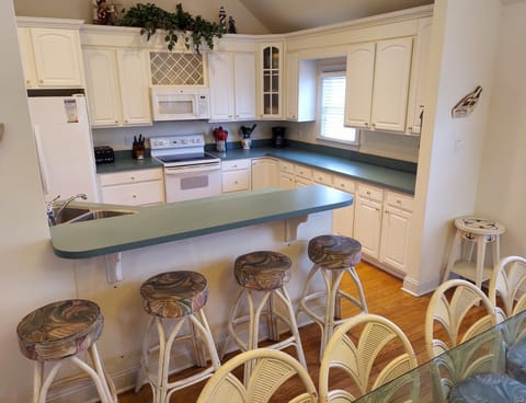 Spacious and well-stocked kitchen with 4 bar stools