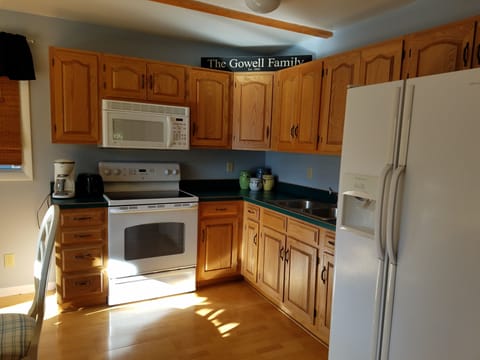 Kitchen includes stove, oven, microwave, fridge, toaster and coffee maker.