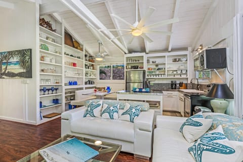 Living, dining and kitchen area with wall of glassware and open shelving