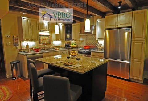 Kitchen with stainless counters, granite island, and seating for 3
