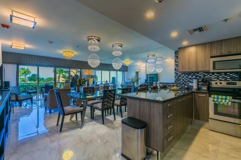 Gather around this sleek kitchen island where your group can cook, dine, and connect under sparkling chandeliers, all with palm-framed views just beyond your terrace.