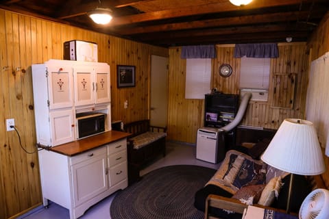 The cottage main room with futon and original Hoosier cabinet.