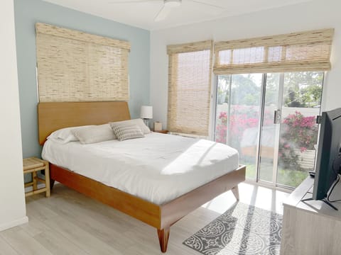 Master bedroom with flat-screen Smart TV and sliding doors to private outdoor 