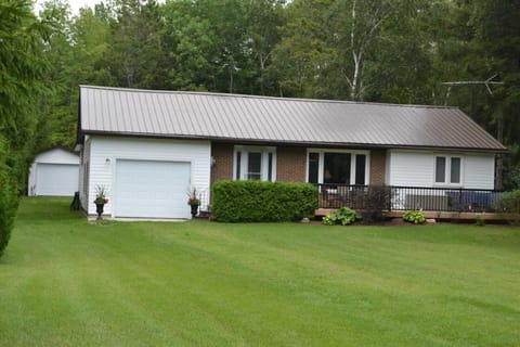 Front of the cottage includes large deck with seating area.