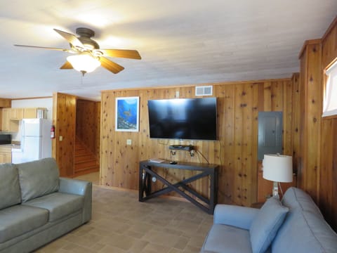 Entry level living room area has a very large smart tv and cable