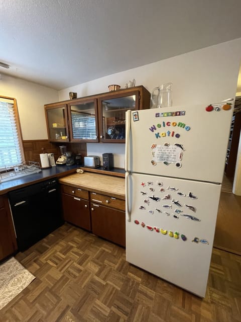 Kitchen, opening to laundry, bathroom, living room, and front porch on right.