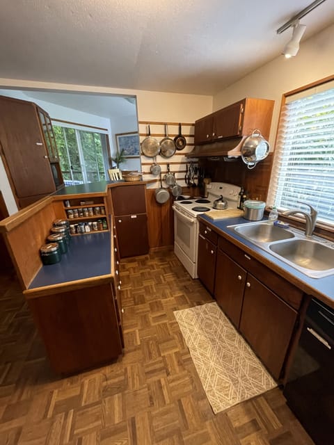 Light-filled kitchen with water view opening to dining room and backyard/deck.