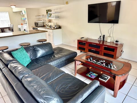Bright open-concept living room with Fussball coffee table. 