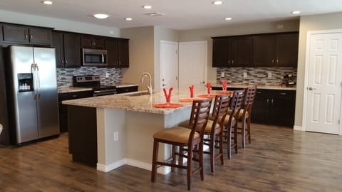 Large kitchen with stainless steel refrigerator, stove, microwave, & dishwasher