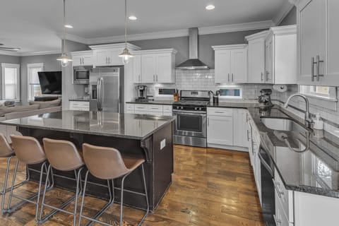 Kitchen equipped with high-end appliances, a sprawling island with seats for 4, custom cabinetry