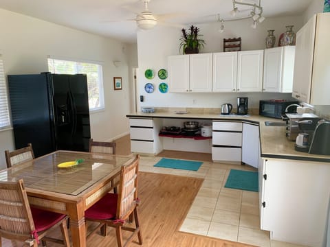 Kitchen with full size fridge, dining table, lots of small appliances