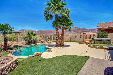 View of pool, outdoor fireplace, fire pitwith seating bench, hot tub