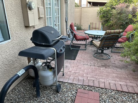 Back patio with table and chairs, grill and also a bike rack