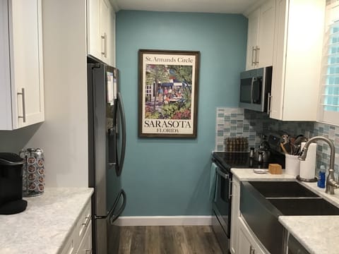 New refrigerator, stove, microwave, Kurieg, cabinets, countertops and sink.