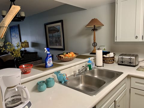 Kitchen has open bar with two stools, Plus dining table with four chairs.
