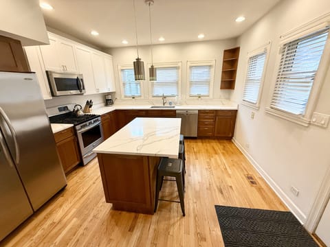 Kitchen with center island, quartz countertops, stainless appliances
