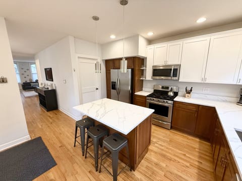 Kitchen with center island, quartz countertops, stainless appliances