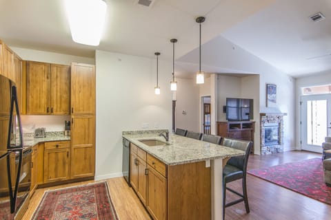 Kitchen - Granite counters, full size appliances, and bar stool seating at the island.