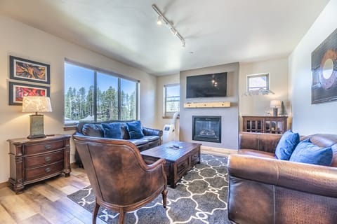 Living Area - Flat screen TV, fireplace, large windows, and natural lighting.