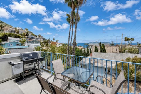 Fire up the grill and savor your morning coffee with sweeping coastal views from your private terrace, where palm trees frame glimpses of the sparkling ocean beyond.