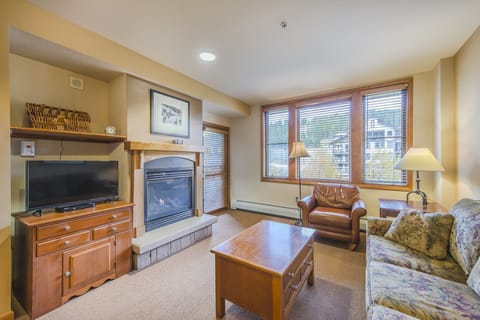Living Area - Queen size sofa sleeper, gas fireplace, access to private balcony, and flat screen TV.