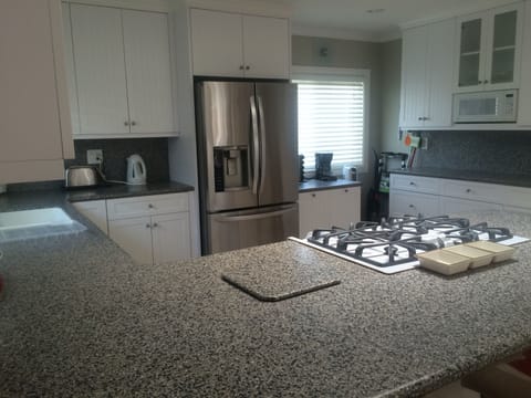The kitchen features a stainless steel refrigerator with beverage center.