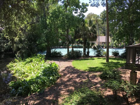 View from the deck over to the tennis court, pool, grill and firepit