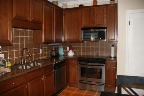 Kitchen has solid surface counters, tile floors and top of the line appliances.