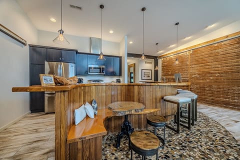 Rustic kitchen with wood accents, unique bar seating, and cozy lighting.