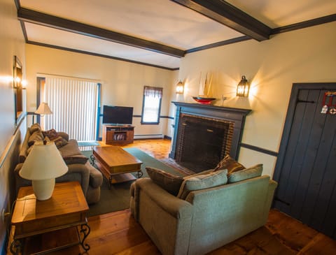 main living room with oversized fireplace and beamed high ceiling
