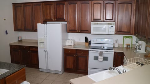 kitchen view with side by side, glass top range, dishwasher & cherry cabinets 
