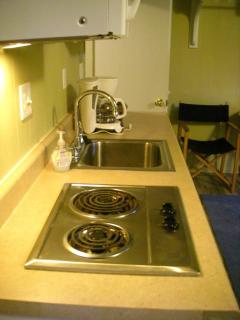 Cook top, microwave, fridge, sink, coffee maker, toaster, utensils & pots/pans.
